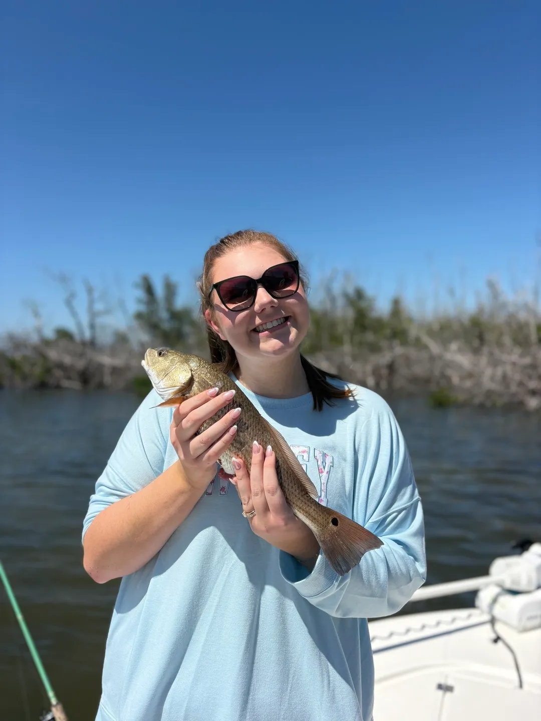Woman holding fish on boat