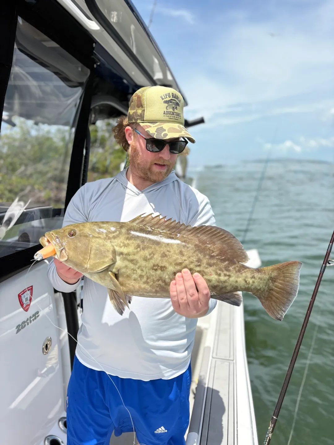 Man holding large fish on boat