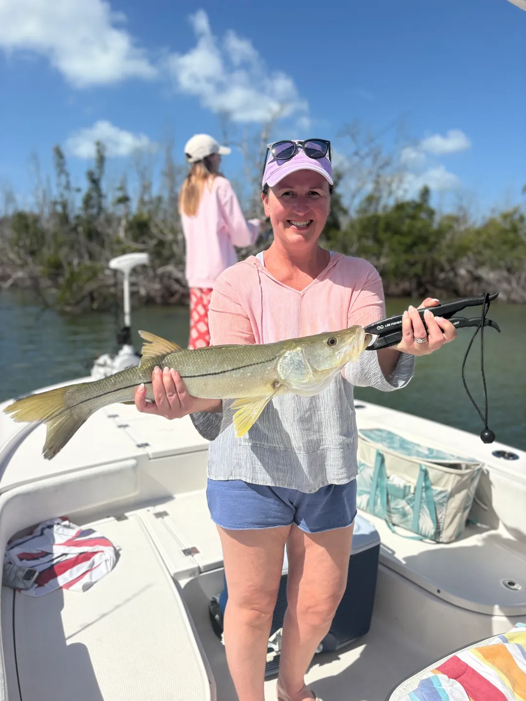 Smiling woman with fish on boat