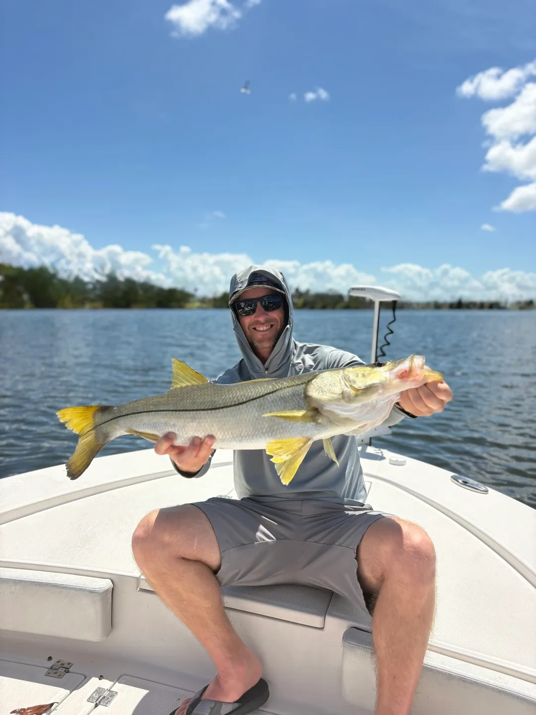 Angler with a catch under blue sky.