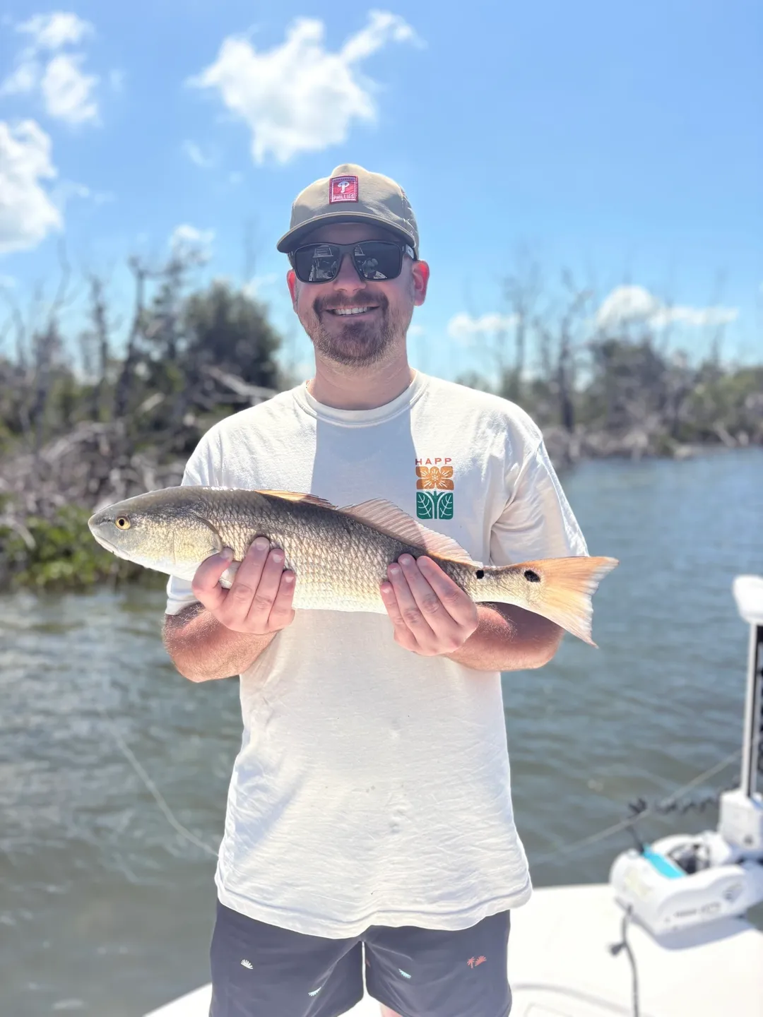 Person showing off a fish outdoors