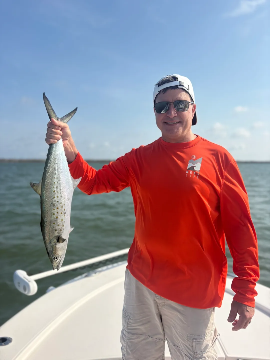 Fisherman in red shirt holding fish