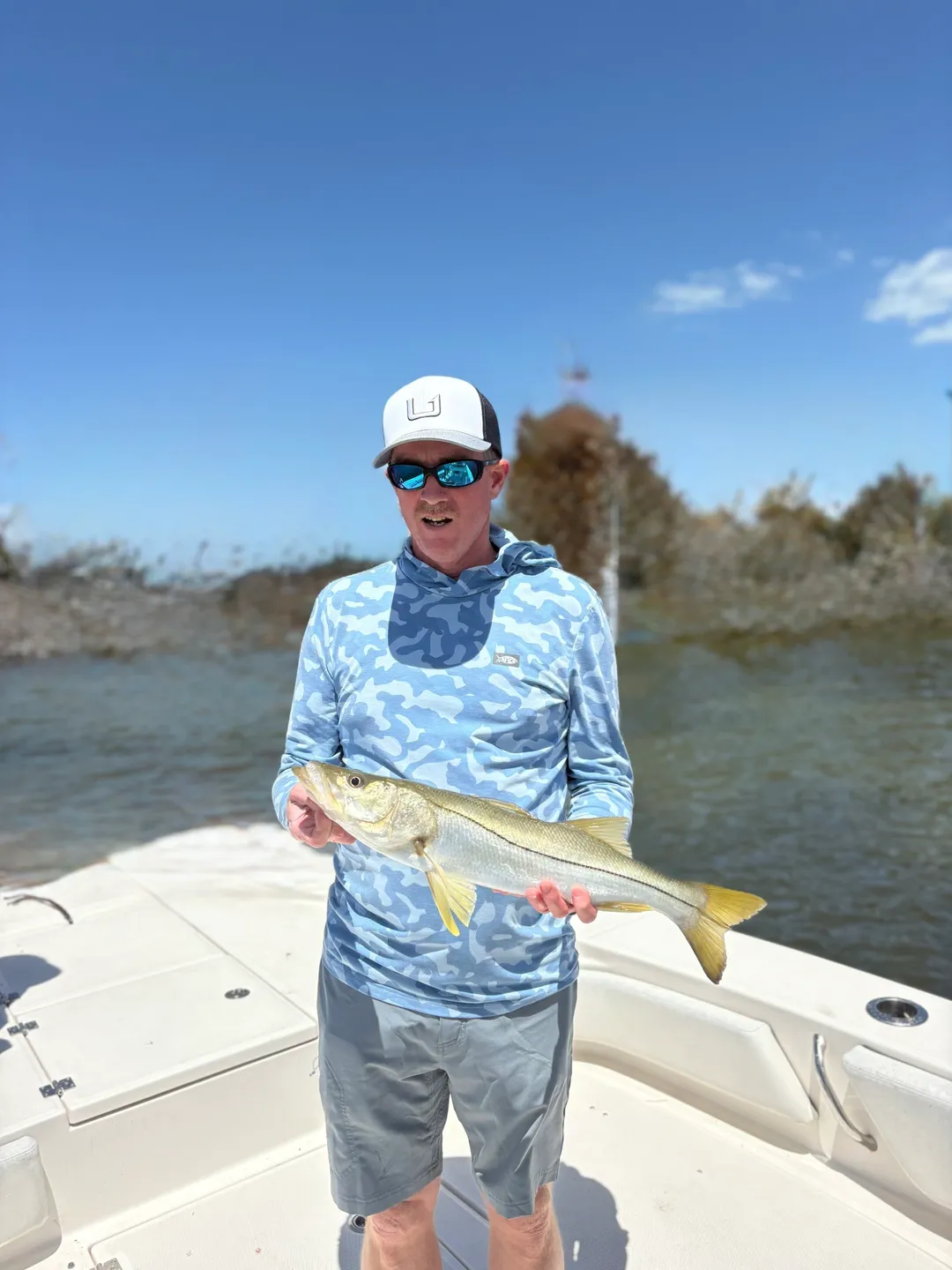 Fisherman with blue shirt and fish