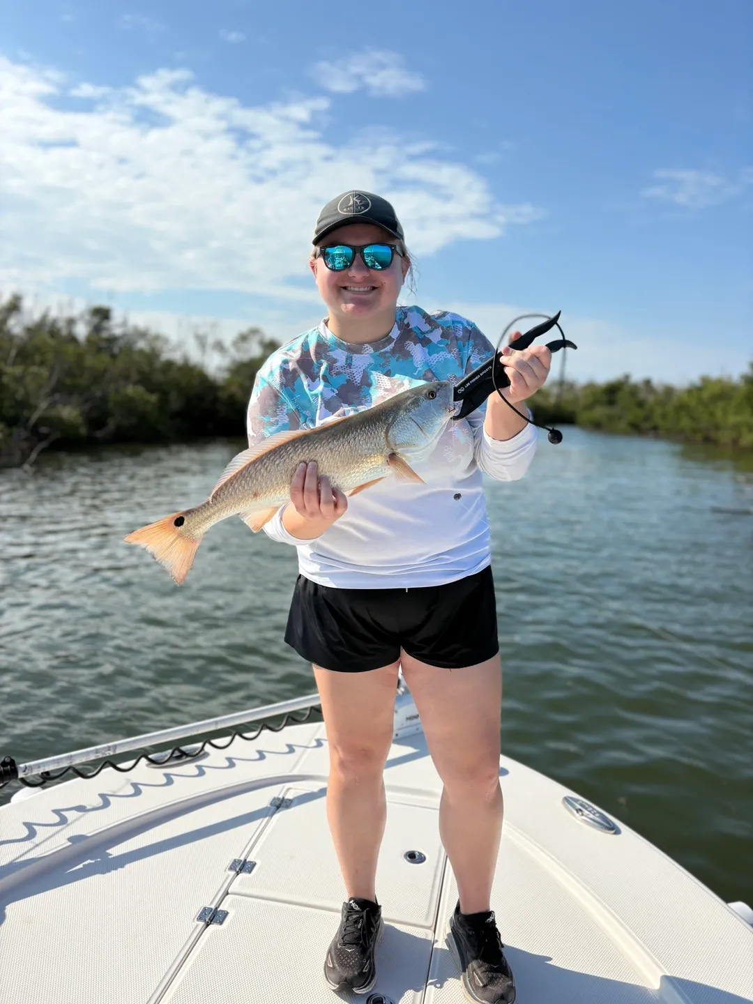 Person holding fish on a boat