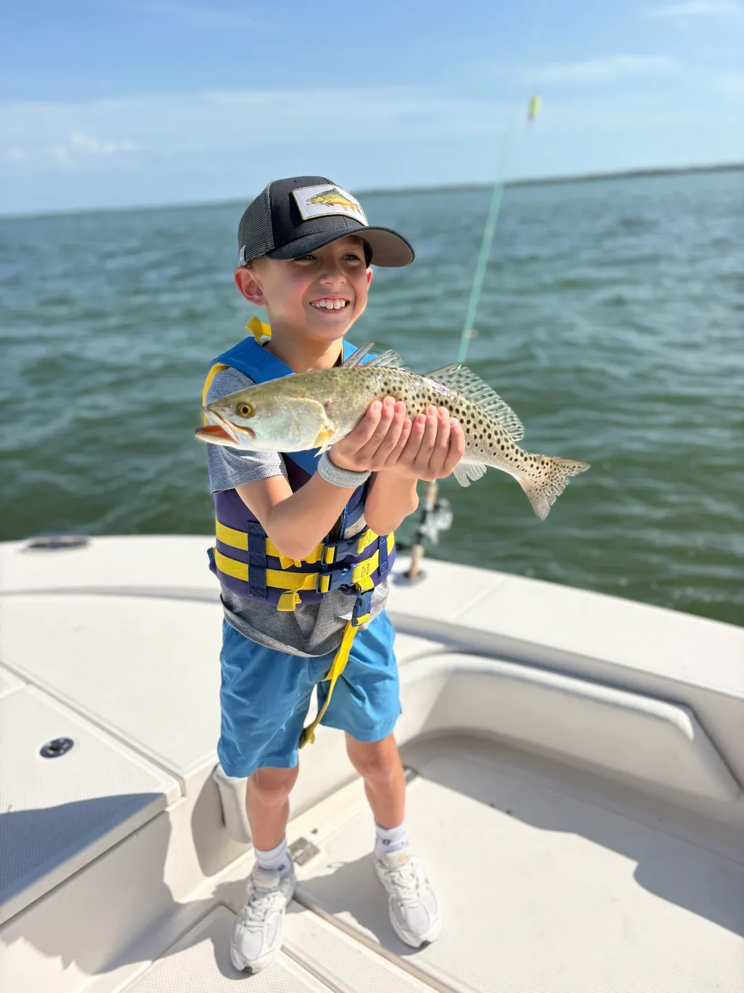 Child holding a fish on a boat