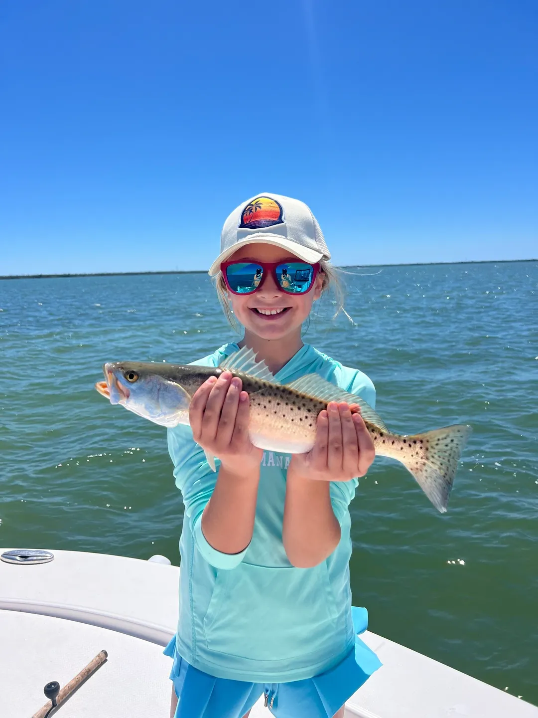 Child holding a fish on a boat