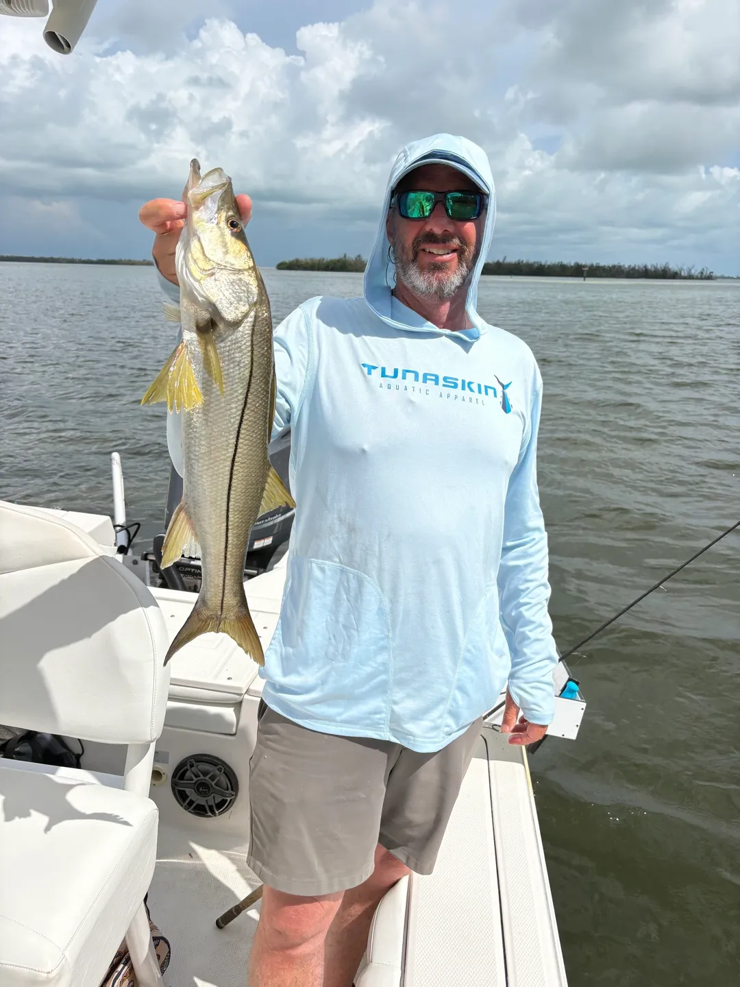Fisherman proudly displays catch on sunny day