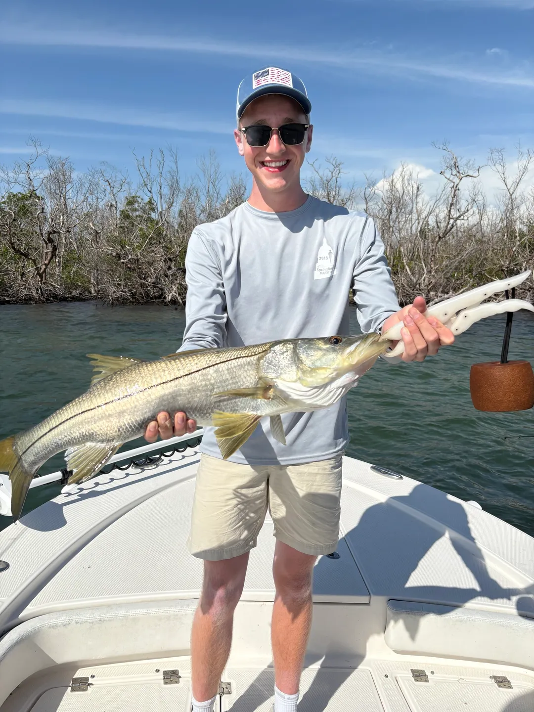 Man holding a large fish on boat