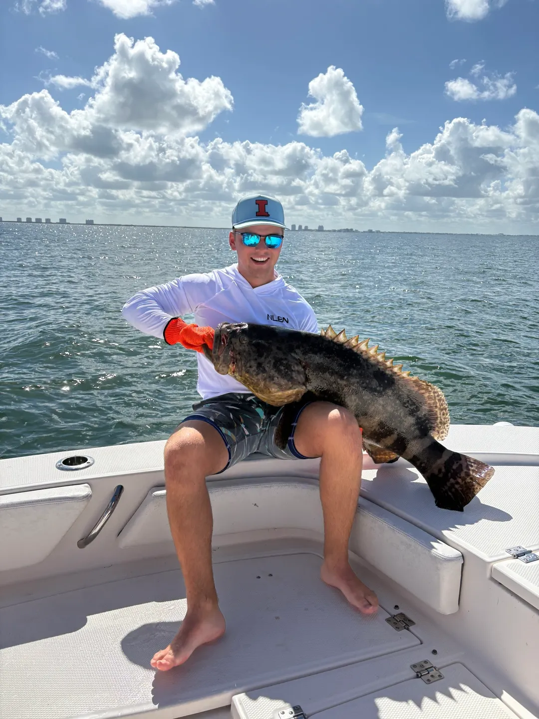 Man holding large fish on boat