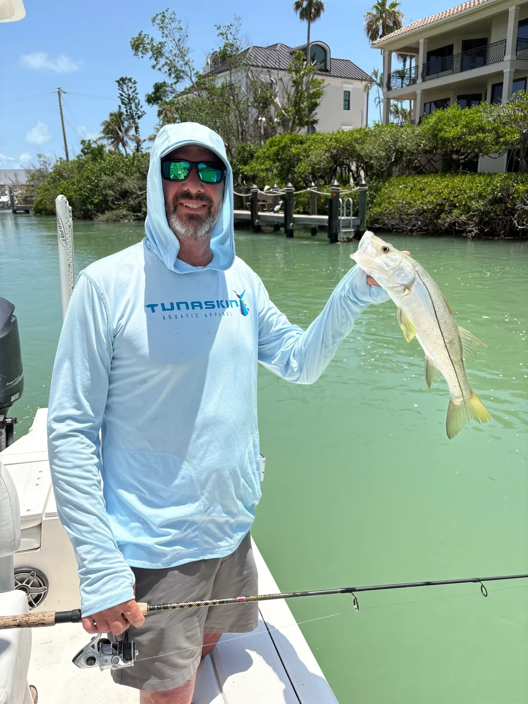 Fisherman in sunglasses catches fish