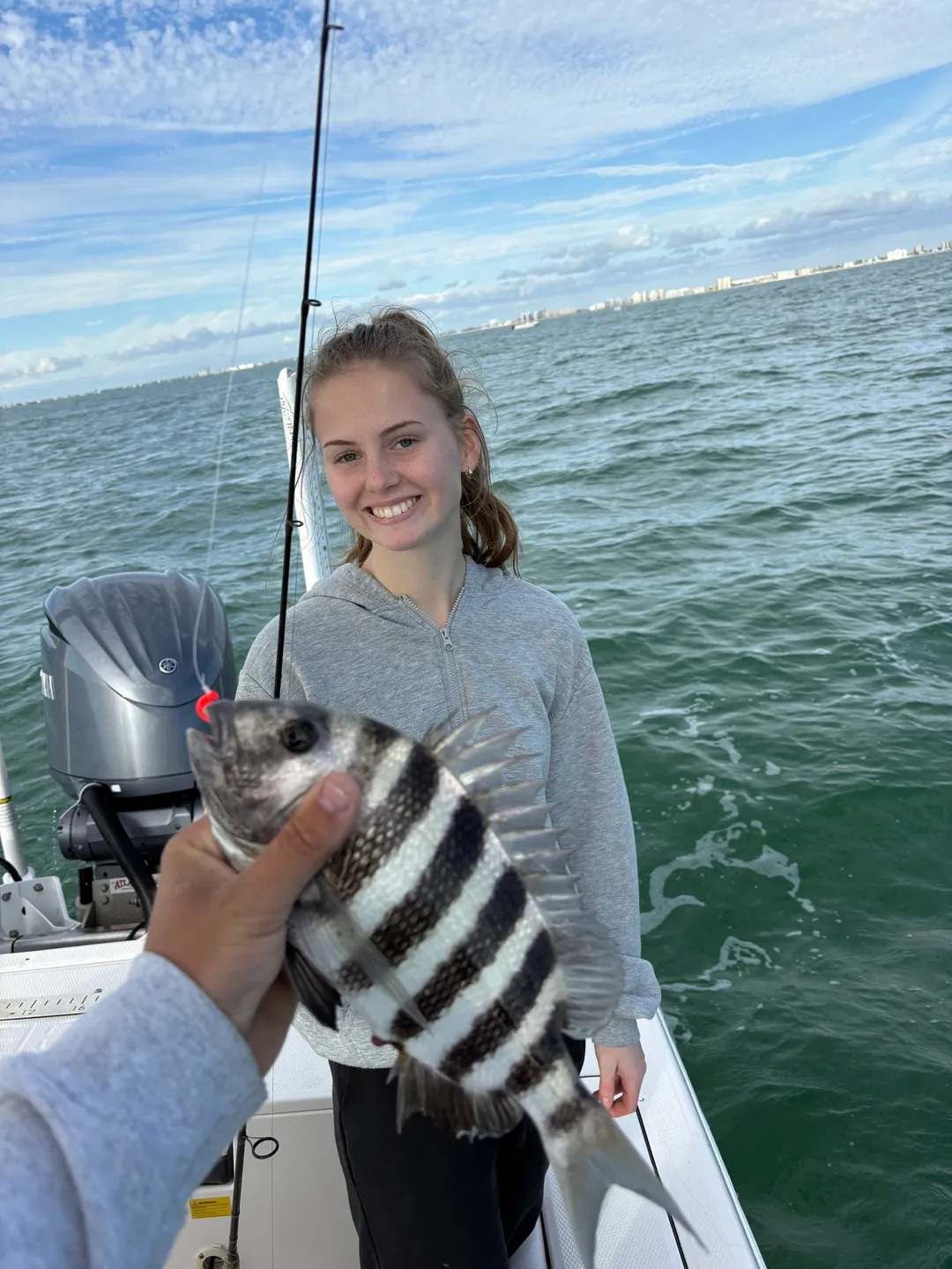 Person holding fish on a boat
