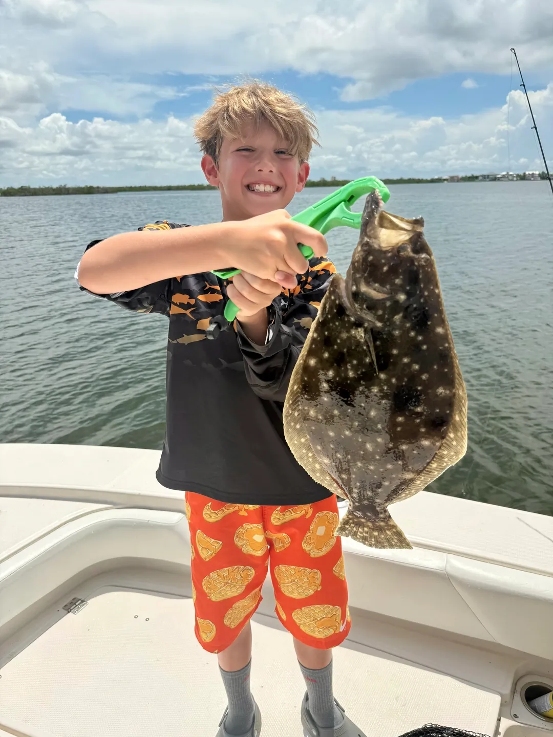 Boy holding a fish on a boat