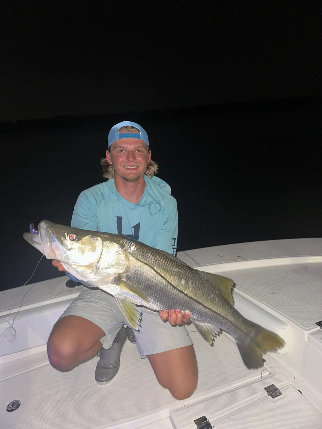 Man holding large fish on boat