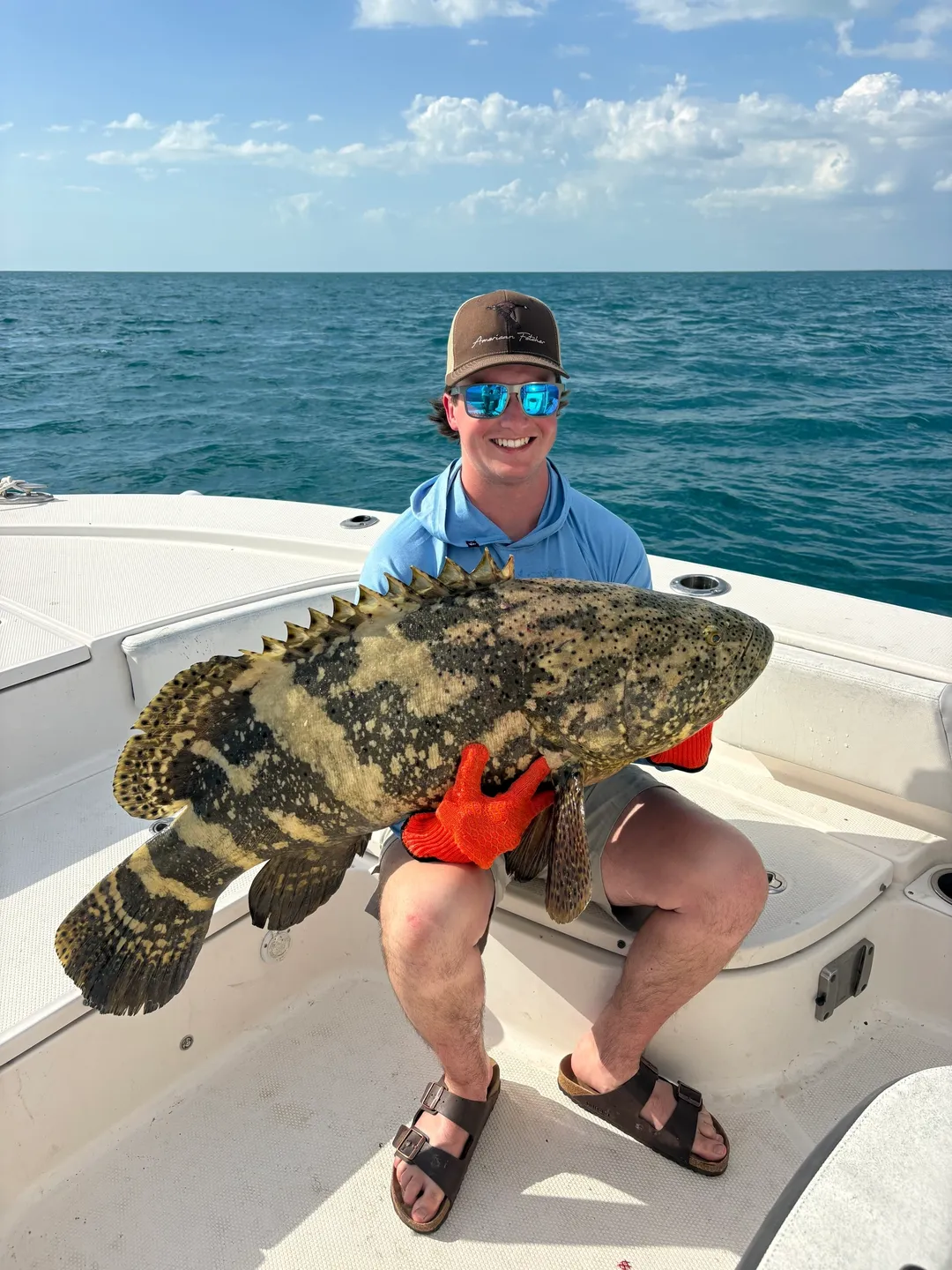 Smiling fisherman showcasing grouper fish