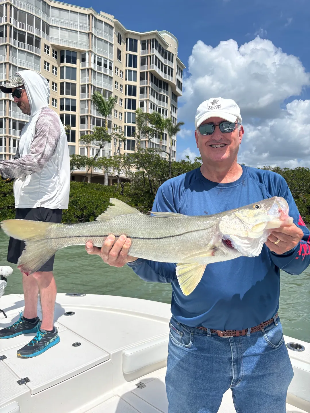 Man holding large fish on boat