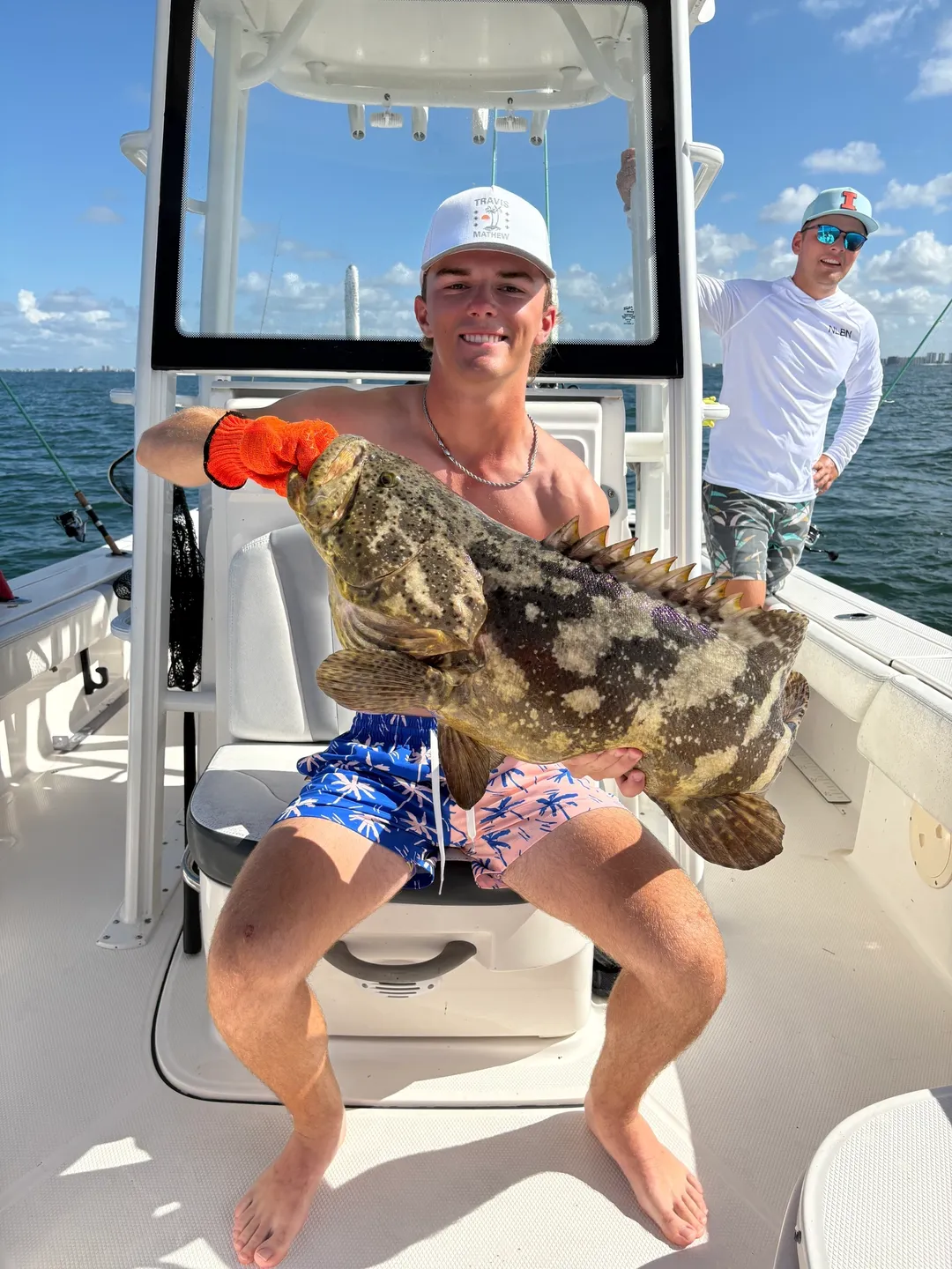 Proud angler displays grouper on boat
